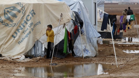 A Syrian refugee plays Thursday after heavy rain at the Zaatari refugee camp in Jordan.